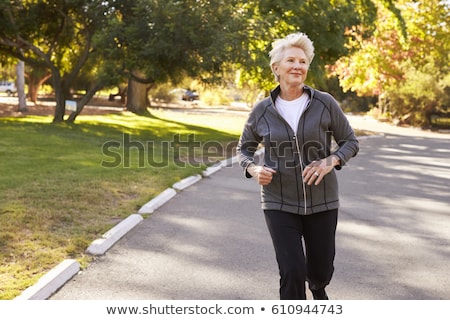 Foto d'archivio: Senior Woman Jogging Through Park