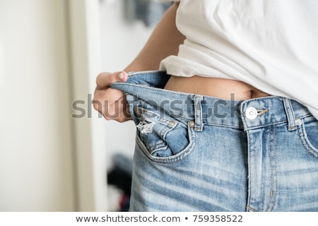 Foto stock: Fit Young Woman In Loose Jeans