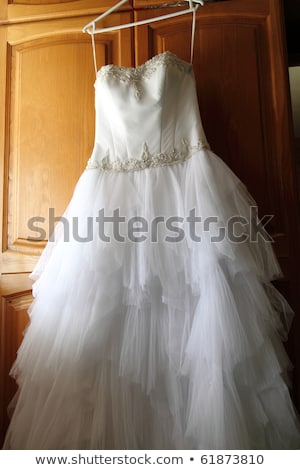 Stockfoto: Beautiful Wedding Dress Hanging On A White Cupboard