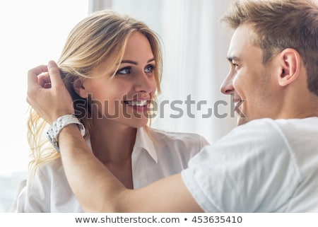 Foto stock: A Blonde Woman And A Man Are Looking At Each Other The Woman Is Taking An Apple The Background Is