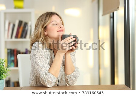 Foto d'archivio: Young Woman Holding Cup Of Tea Or Coffee At Home And Breathing A