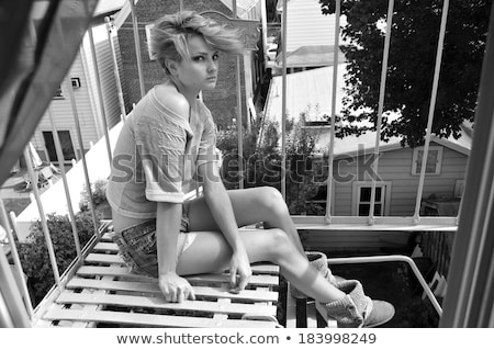 [[stock_photo]]: Pretty Woman On Fire Escape Stair