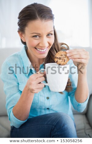 Stockfoto: Woman Dipping A Cookie Into A Mug