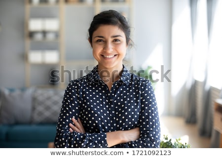 Stok fotoğraf: Portrait Of A Smiling Young Woman Laughing With Arms Folded