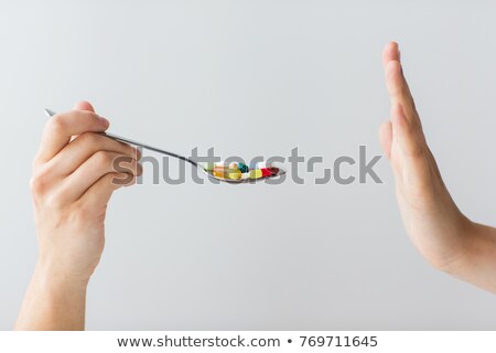 Foto d'archivio: Hand Of Woman Refusing From Pills On Spoon