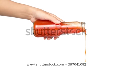 Foto stock: Hand Pouring Fruit Juice From Bottle To Glass