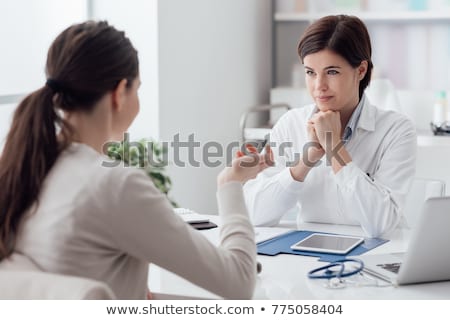 [[stock_photo]]: Female Doctor At Her Desk With A Patient