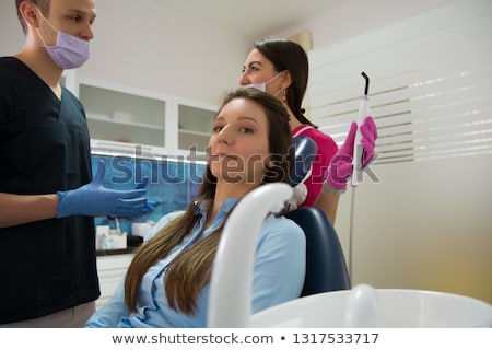 Foto stock: Dentist In Surgical Mask Holding Dental Explorer