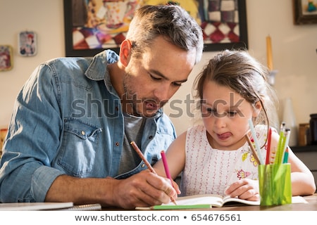 Foto stock: Dad Helps His Child To Write At Home