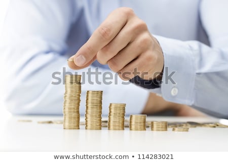 Stockfoto: Male Hand Stacking Gold Coins Into Increasing Columns