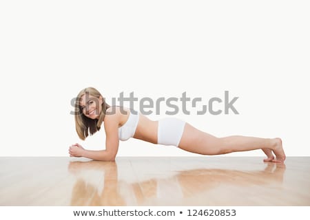 Foto d'archivio: Portrait Of Young Woman Doing Push Ups On Hardwood Floor