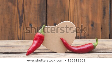 Zdjęcia stock: Red Chilly Peppers With Cardboard Heart On Wood Background