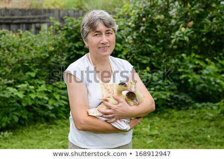 Stock photo: Middle Age Caucasian Woman With Yellow Duckling Outdoors