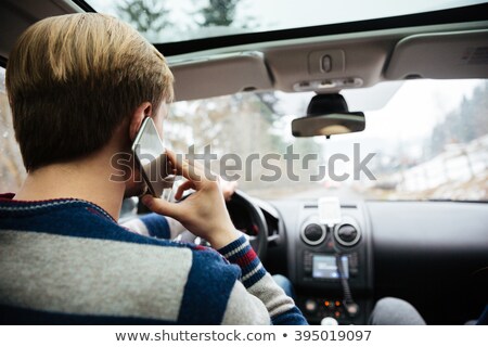 Stok fotoğraf: Man In Striped Sweater Driving And Talking On Mobile Phone