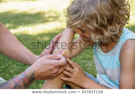 Foto stock: Boy Putting Plaster On Elbow