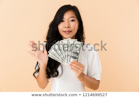 Foto d'archivio: Happy Asian Woman Posing Isolated Over Beige Wall Background Holding Money