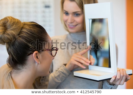 Foto d'archivio: Young Woman Trying Fashionable Glasses In Optometrist Store