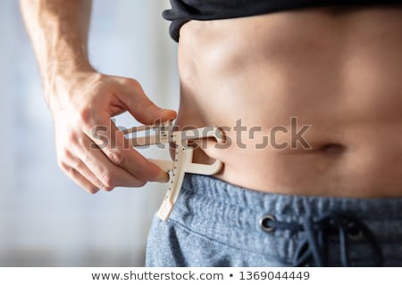 Foto stock: Person Measuring His Body Fat With Caliper