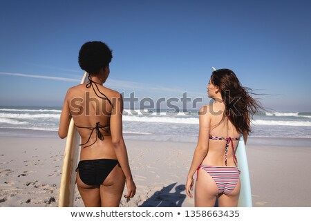 Stok fotoğraf: Rear View Of Young Multi Ethnic Women Holding Their Surfboards While Standing In Front Of The Sea An
