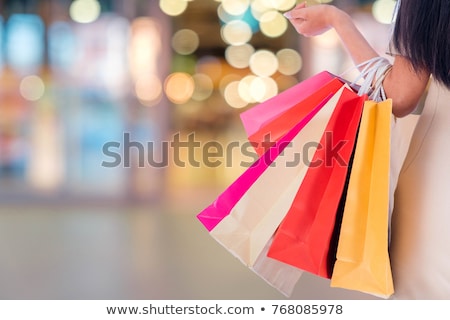 Foto stock: Inda · garota · de · compras · com · sacolas · coloridas · e · garotas · desfocadas · no · fundo