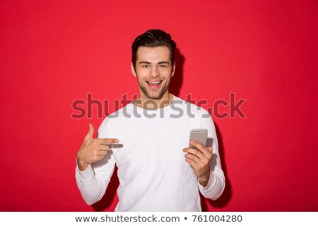 Stockfoto: Portrait Of Young Handsome Smiling Guy In Red Sweater Holding His Hand Near Chin Thinking On Yellow