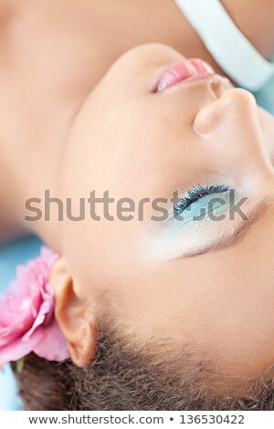 Stock photo: Black Haired Woman Wearing A Flower In Her Hair While Being Naked
