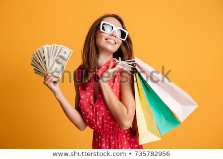 Stock photo: Brunette Holding Cash And Shopping Bags