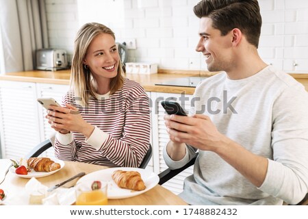 Stok fotoğraf: Couple Using Mobile Phone While Having Meal