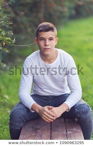 Stylish Teenager Sitting On A Wooden Bench On A City Street Casu Stockfoto © 2Design