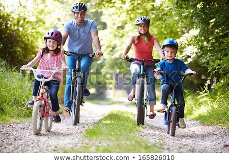 Foto stock: Happy Family Is Riding Bikes Outdoors And Smiling Father On A Bike And Son On A Balancebike