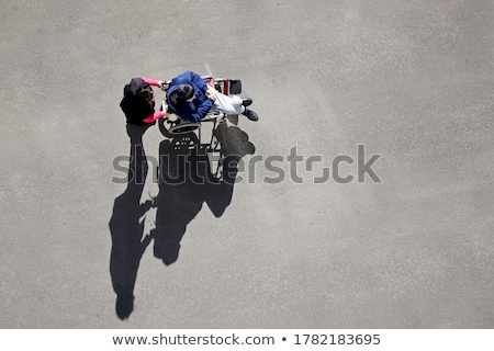 Foto stock: Woman Pushing Wheelchair