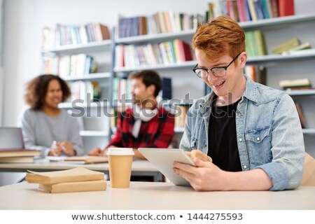 Foto d'archivio: Clever Guy In Casualwear Scrolling In Tablet While Surfing In The Net