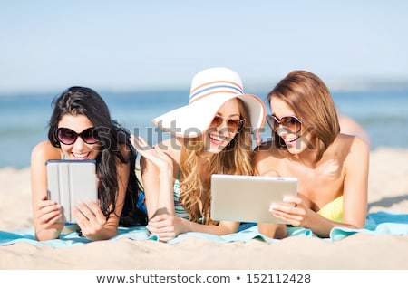 Foto d'archivio: Smiling Woman With Tablet Pc Sunbathing On Beach