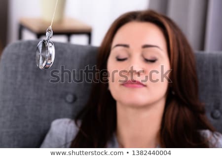 Foto stock: Woman Being Hypnotized While Sitting On Sofa