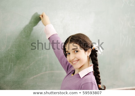Linda garota escrevendo no quadro da sala de aula Foto stock © Zurijeta