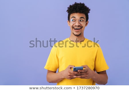 Stockfoto: Happy Young African Man Posing Isolated Over Violet Background Take A Selfie By Phone Holding Basket