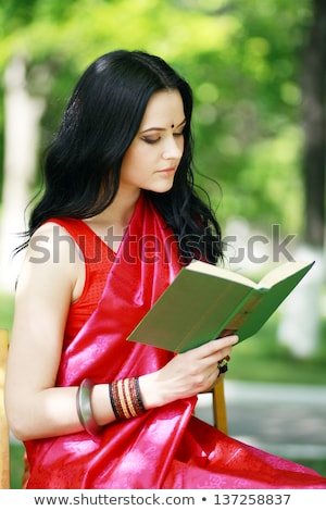 Stock photo: A Shot Of A Smiling College Student Reading A Book At Park