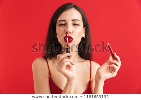 ストックフォト: Woman Posing Isolated Holding Lip Gloss Doing Makeup