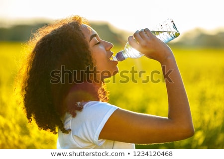 Foto d'archivio: Young Women In Yellow Sport Shirt Are Drinking Water At The Gym