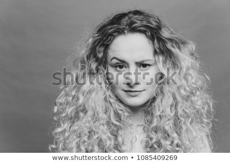 Foto stock: Attractive Female With Bushy Light Curly Hair Raises Her Eyebrow Feels Puzzlement Cant Undersatn