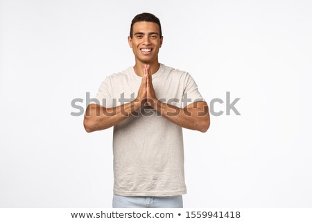 Stockfoto: Happy Carefree Handsome Brazilian Man In Casual Outfit Clasp Hands Together In Pray Namaste Gestu