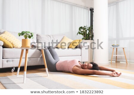 Foto d'archivio: Exhausted Woman Lying With Legs Raised Up And Closed Eyes