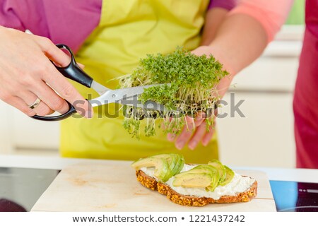 Stock fotó: Woman Cutting Fresh Fenugreek Sprout Over The Sandwich