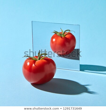 Two Tomatoes With Green Stems Are Reflected In A Mirror On A Blue Pink Double Background With Copy S Сток-фото © artjazz