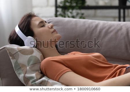 Foto stock: Close Up Of A Teen Girl Listening Music Lying On A Sofa