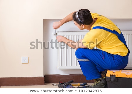 Zdjęcia stock: Young Repairman Contractor Repairing Heating Panel