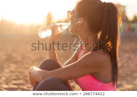Foto stock: Sports Woman In Park Holding Bottle With Water