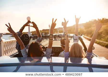 Stok fotoğraf: Happy Couple With Camera Driving In Cabriolet Car