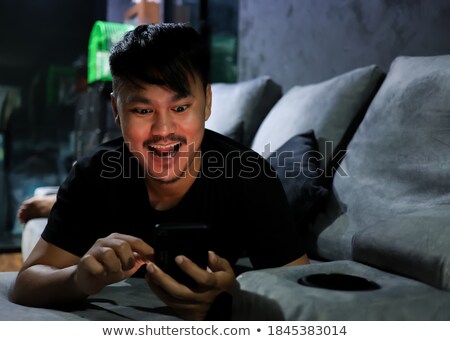 Foto stock: Smile And Happy Face Of Young Asian Man With Phone In Hand Advertising Model Concept With Blue Shir