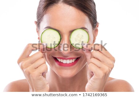 Foto d'archivio: Cute Brunette Holding Cucumber Slices Over Eyes